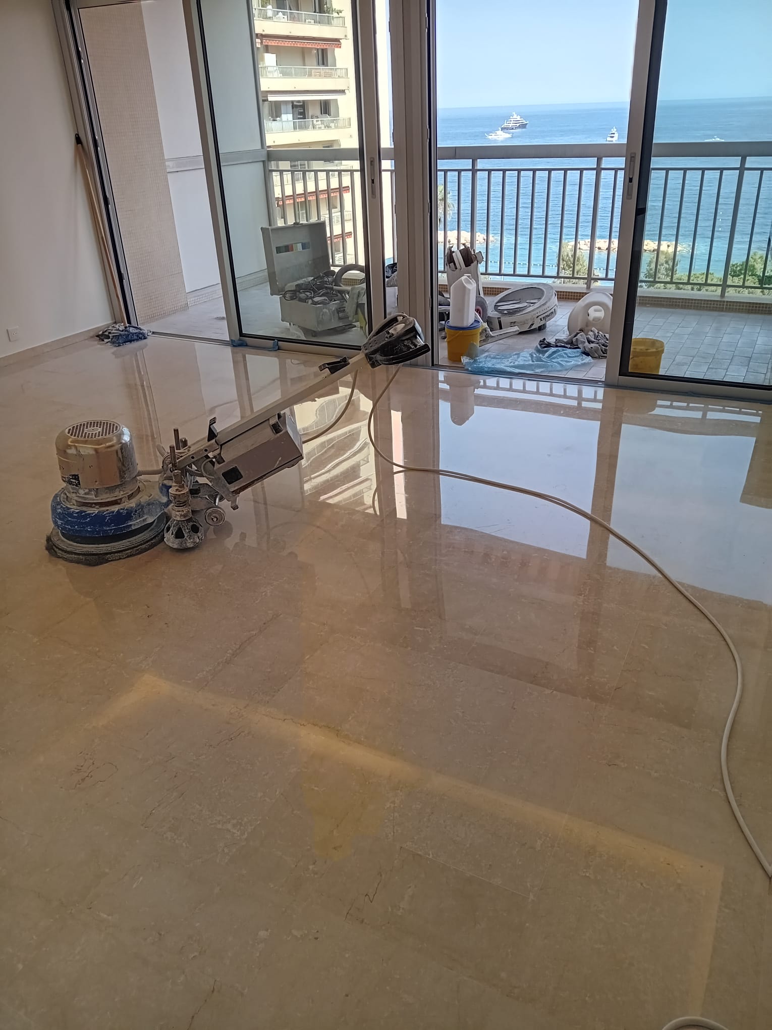 Crema Marfil marble floor being polished with professional grinding machine by MarblePro — apartment with sea view in Dubai