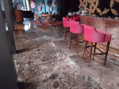 Dark Emperador marble floor polished to a deep gloss in a Dubai lounge by MarblePro — rich chocolate-brown stone restoration