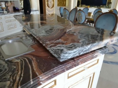 Fusion WOW quartz kitchen countertop detail polished by MarblePro — swirling burgundy and grey veining, Dubai villa